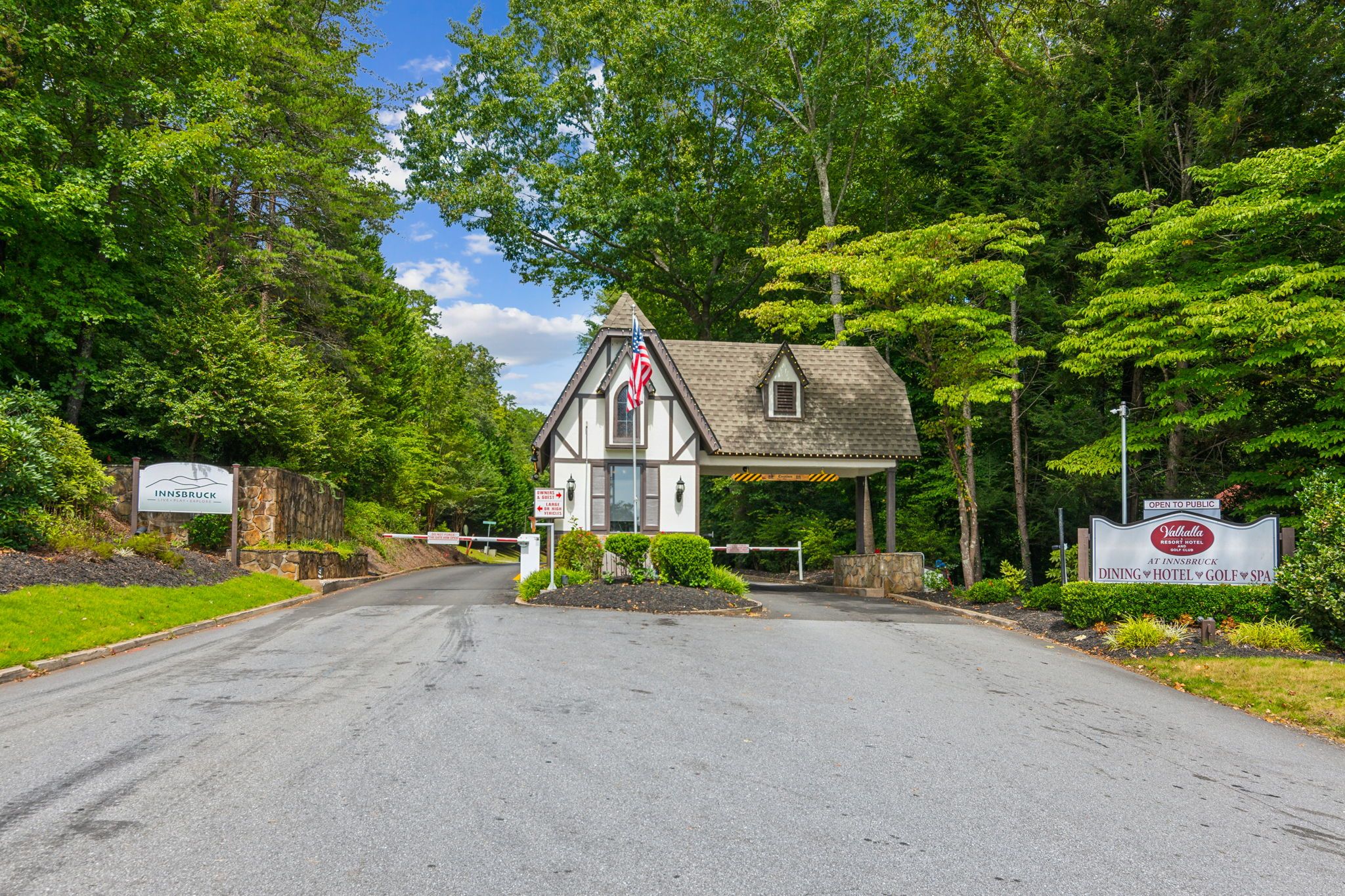 Un bâtiment à deux étages, doté d’une façade en pierre, d’un drapeau et d’une enseigne indiquant qu’il s’agit d’un établissement public proposant des services de restauration, d’hébergement, un parcours de golf et un spa.