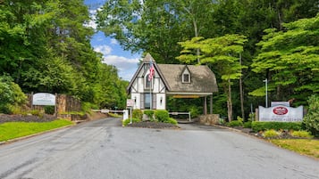 Un bâtiment à deux étages, doté d’une façade en pierre, d’un drapeau et d’une enseigne indiquant qu’il s’agit d’un établissement public proposant des services de restauration, d’hébergement, un parcours de golf et un spa.