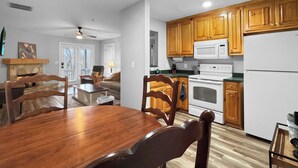A spacious kitchen with wooden cabinets, a white refrigerator, and a dining area with a wooden table and chairs.