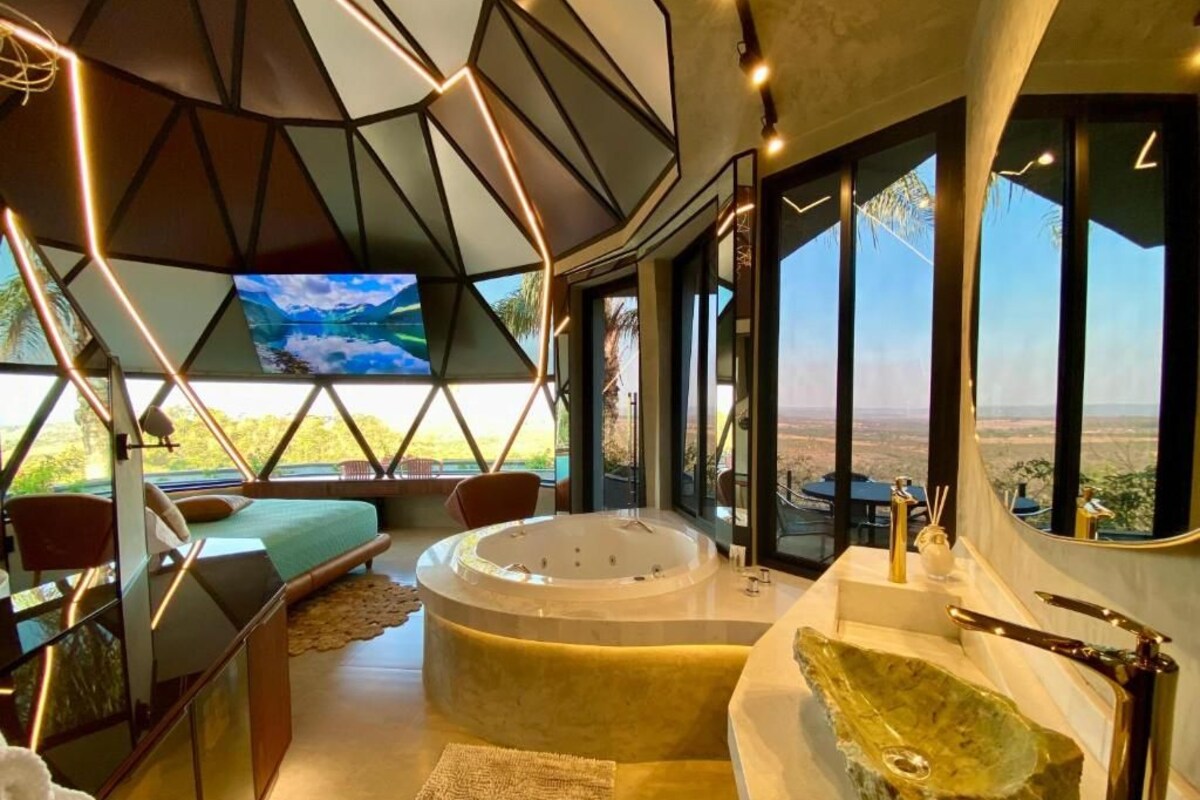 A modern interior with a large bathtub, seating area, and a television.