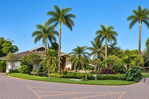 A hotel with a paved driveway, palm trees, and a well-maintained lawn. - Mirante Pousada Boutique (Primavera do Leste)