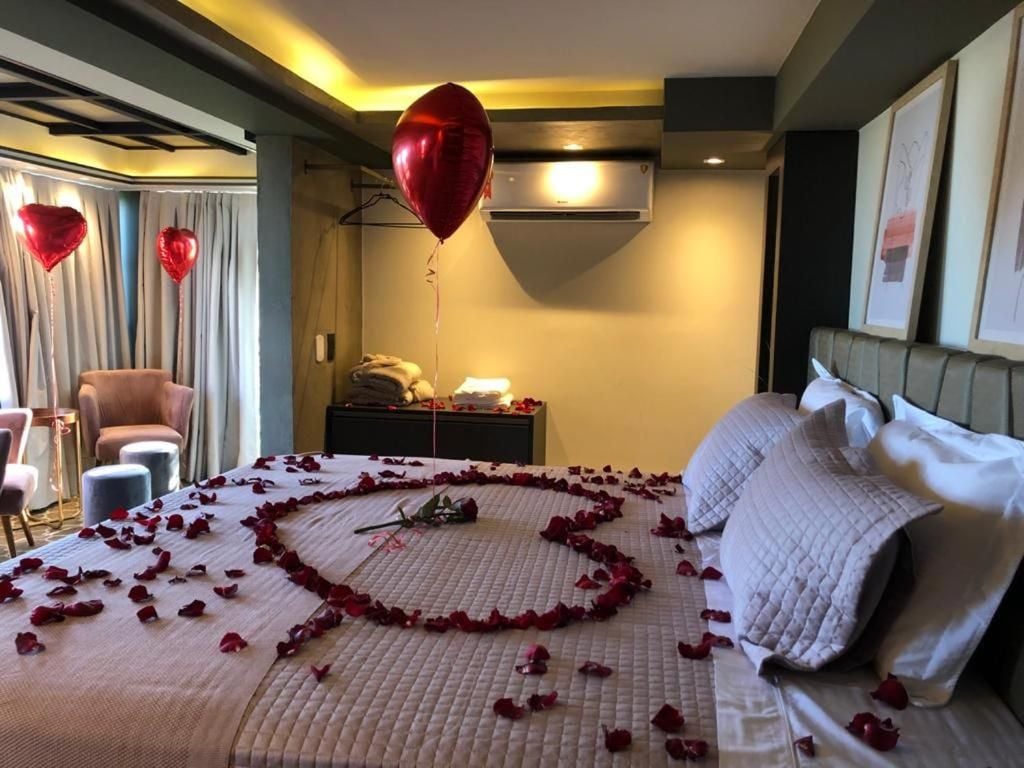Een hotelkamer met een bed, nachtkastje, stoel en een wandairconditioner.