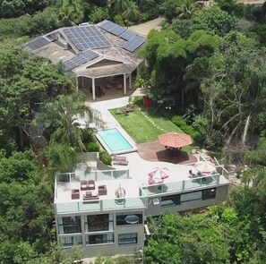 A modern house with a swimming pool, solar panels, and a covered patio. - Mirante Pousada Boutique (Primavera do Leste)