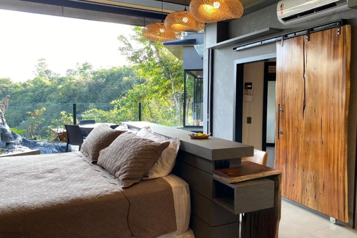 A modern bedroom with a bed, bedside table, and wardrobe.