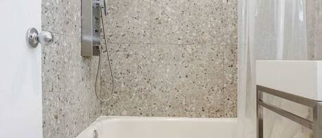 Une salle de bain avec une baignoire sur pieds, une douche et des toilettes.