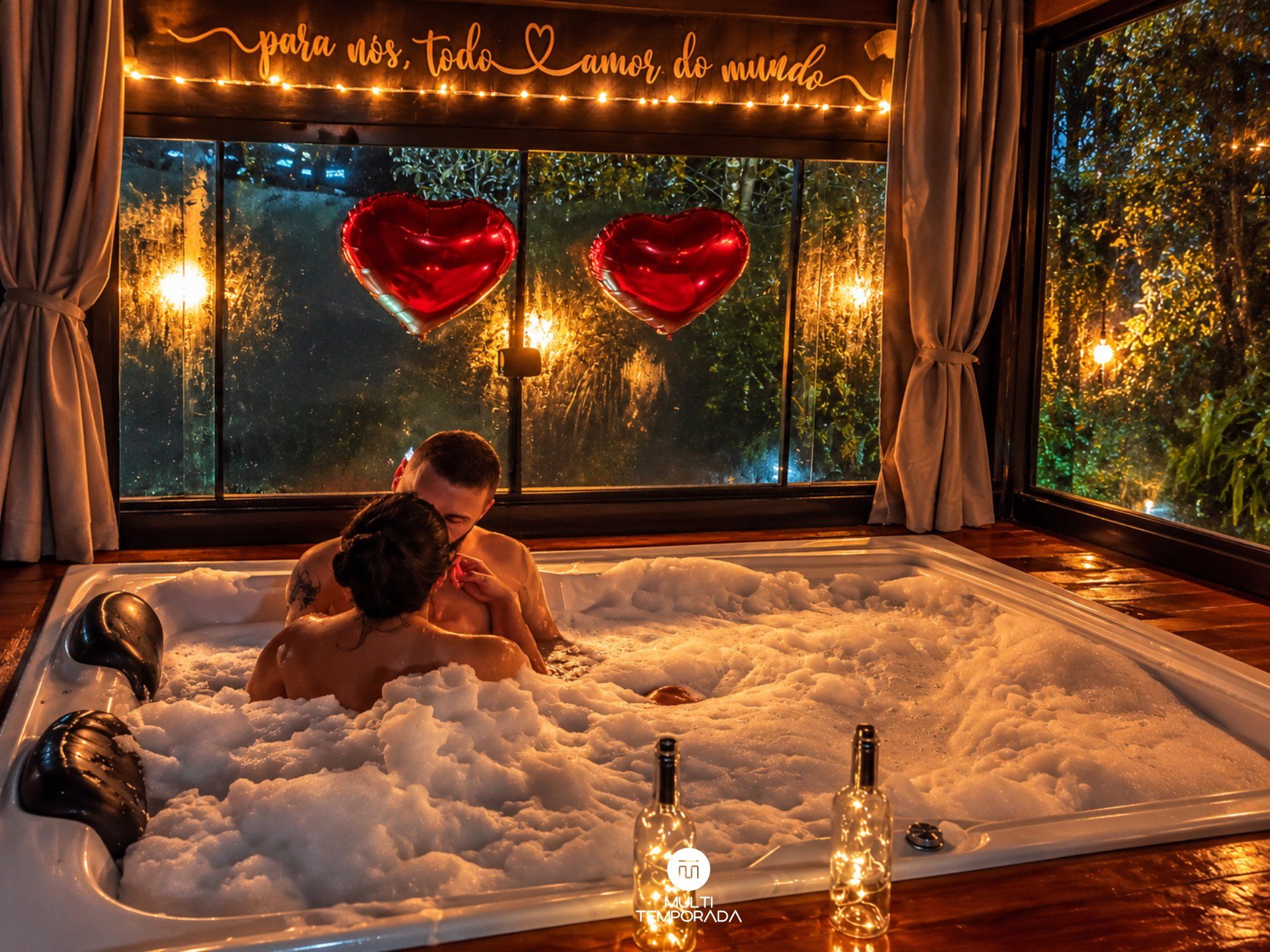 Una pareja en un jacuzzi con globos con forma de corazón y un letrero que dice 'para nos, todo amor do mundo'.