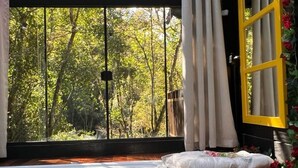 Un bain à remous avec vue sur les arbres, une fenêtre à cadre jaune et une pancarte sur laquelle on peut lire « Amor ».