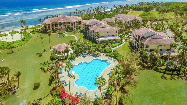 Un complexe hôtelier comprenant plusieurs bâtiments, une piscine et offrant une vue sur la plage.