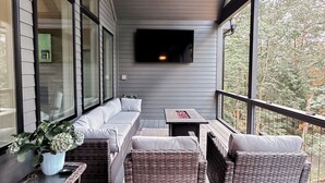 A covered porch with wicker furniture, a ceiling fan, and a mounted TV. - Luxury Lake Home on Golf Course (Waleska)