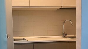 A compact kitchen with a sink, cabinets, and a countertop.