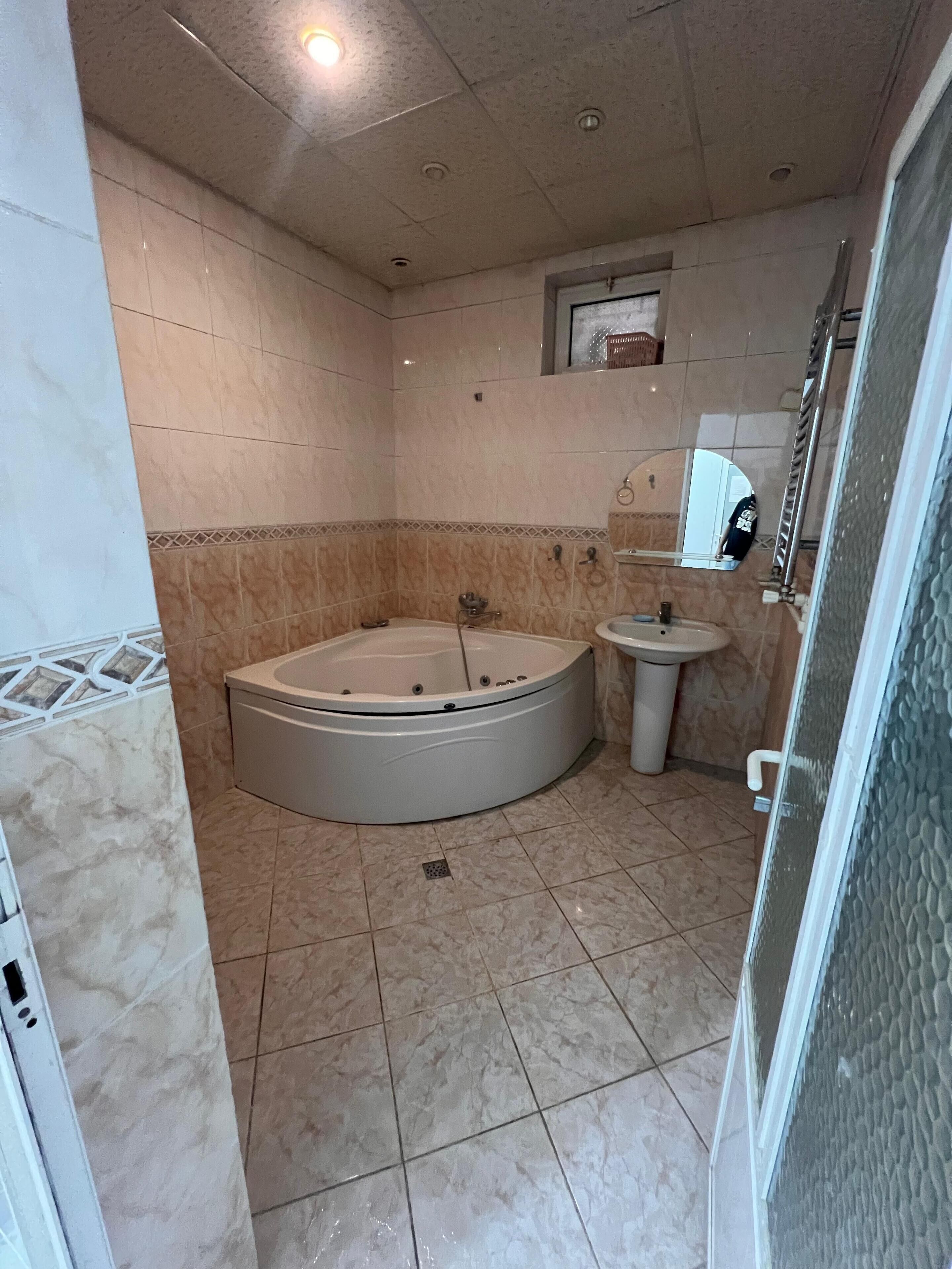 Un baño con bañera, lavamanos y espejo.