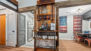 Un café rústico con un letrero de madera, estantes con tazas y un fondo de pared de ladrillo.
