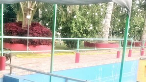 Une personne se trouve dans une piscine, avec une vue dégagée sur le bord de la piscine et les environs.