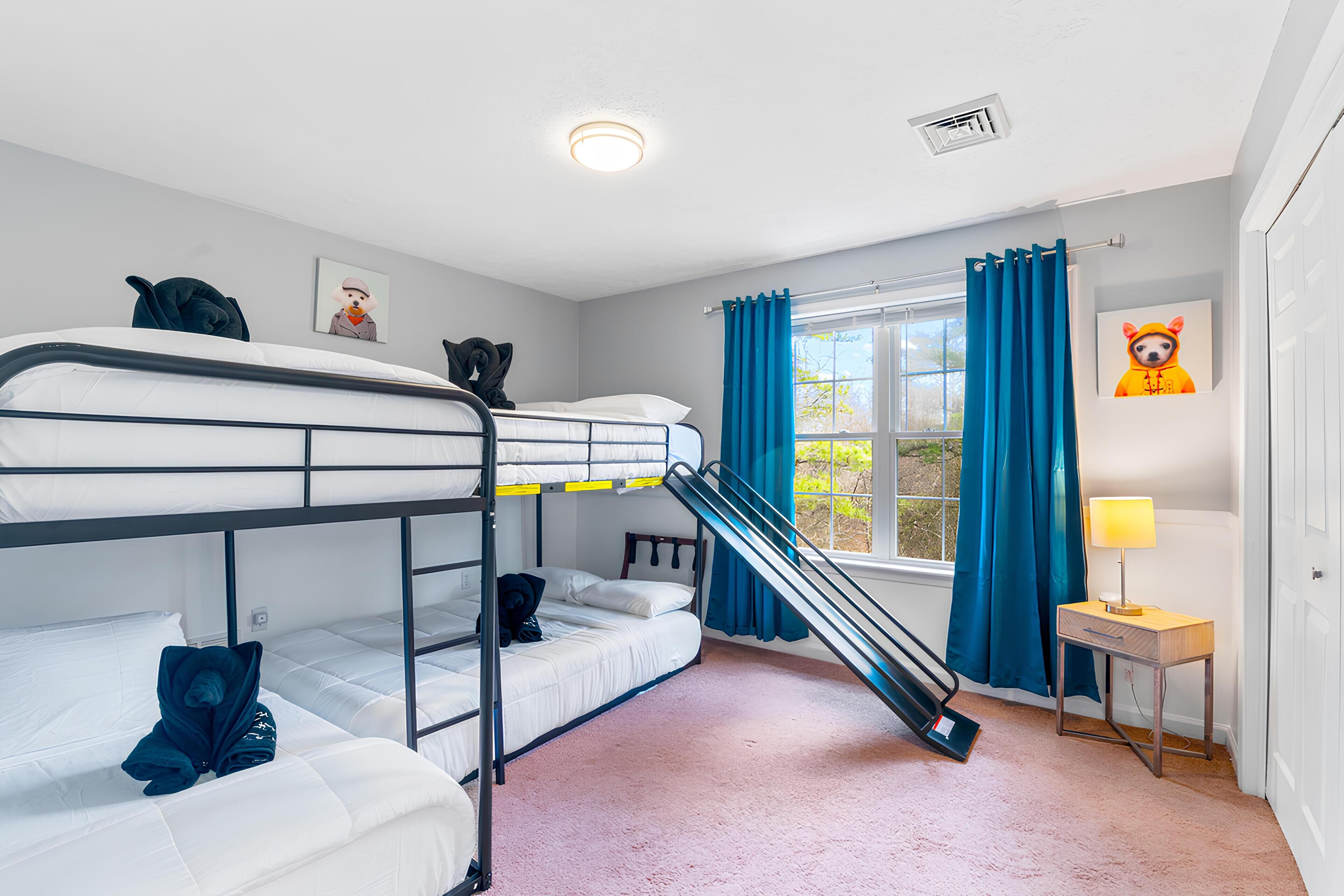 Quarto com beliche, escrivaninha e abajur.