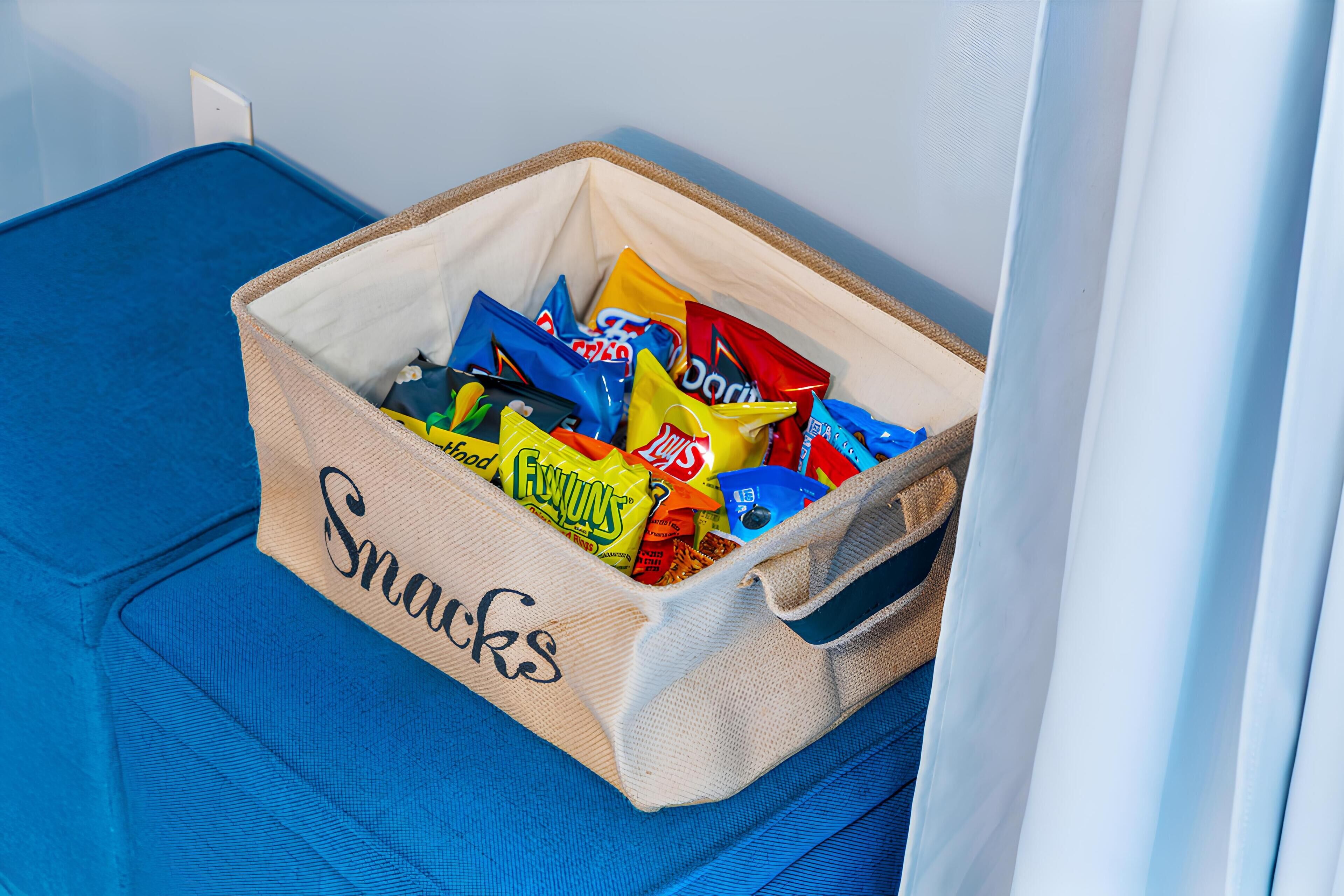 A storage bin labeled "Snacks" filled with various snack packets.