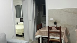 A compact living space with a dining table, a sofa, and a small potted plant. - A family owned house (Ulcinj)