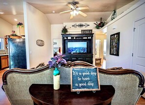 A living room with a television, a sign that says "It's a good day to have a good day," and a decorative vase. - 3-bedroom house in charming Jerome with AC (Jerome)