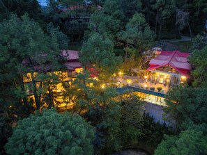 Een resort met meerdere gebouwen, buitenzitplekken en een zwembad.