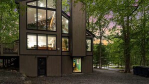 Un bâtiment moderne à deux étages, doté de grandes fenêtres et entouré d’arbres.