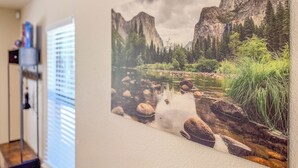 Una pintura de un paisaje montañoso con un río y rocas.