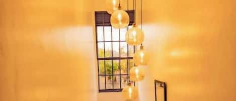 A staircase with a wooden handrail and a hanging light fixture.