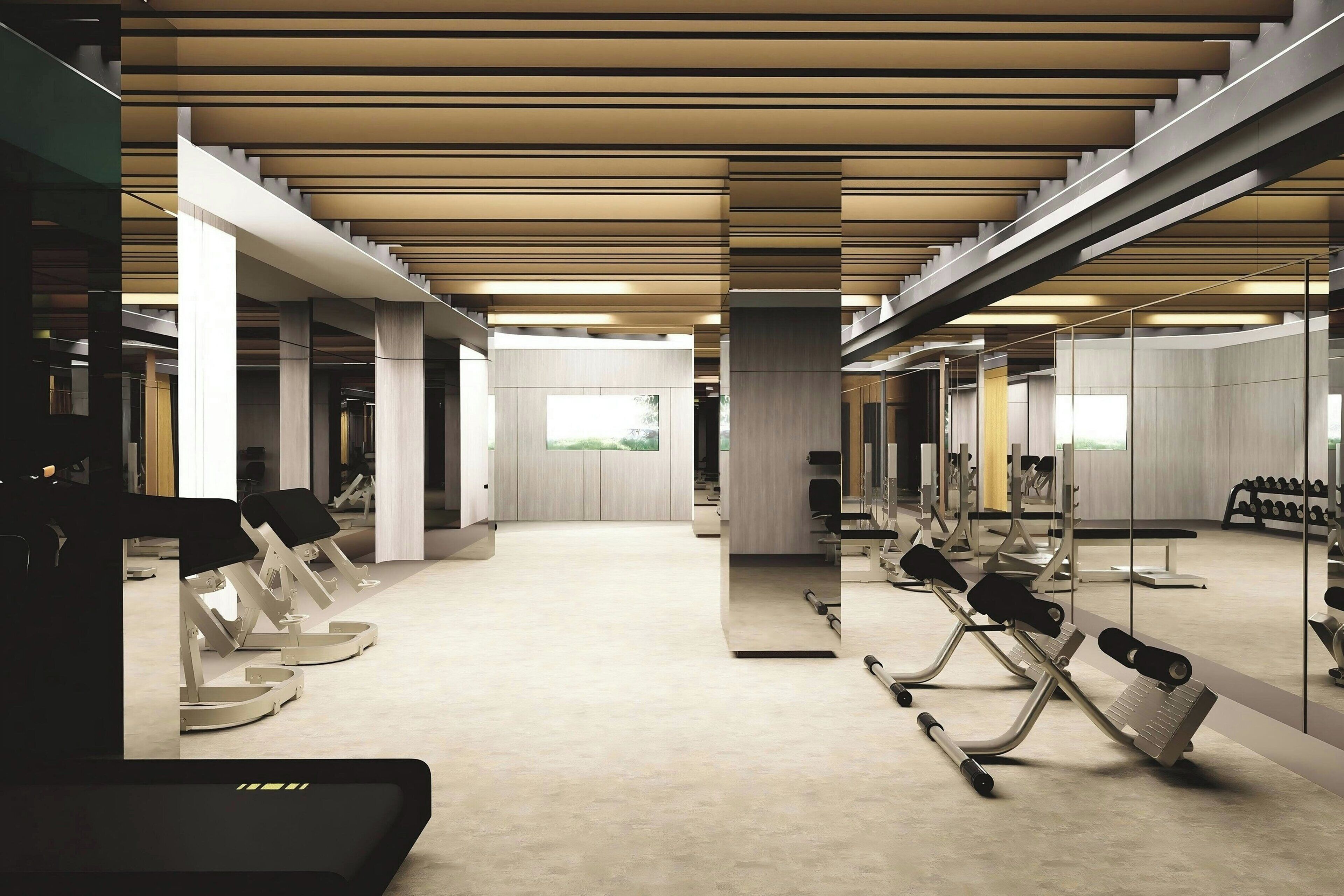 A modern gym with exercise equipment, a large mirror, and a spacious layout.