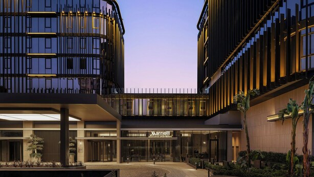 A modern hotel with a curved facade, large glass windows, and a well-lit entrance. - Marriott Executive Apartments Antalya (Antalya)