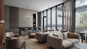 A modern living room with a sofa set, a dining table, and a kitchen area with bar stools. - Marriott Executive Apartments Antalya (Antalya)