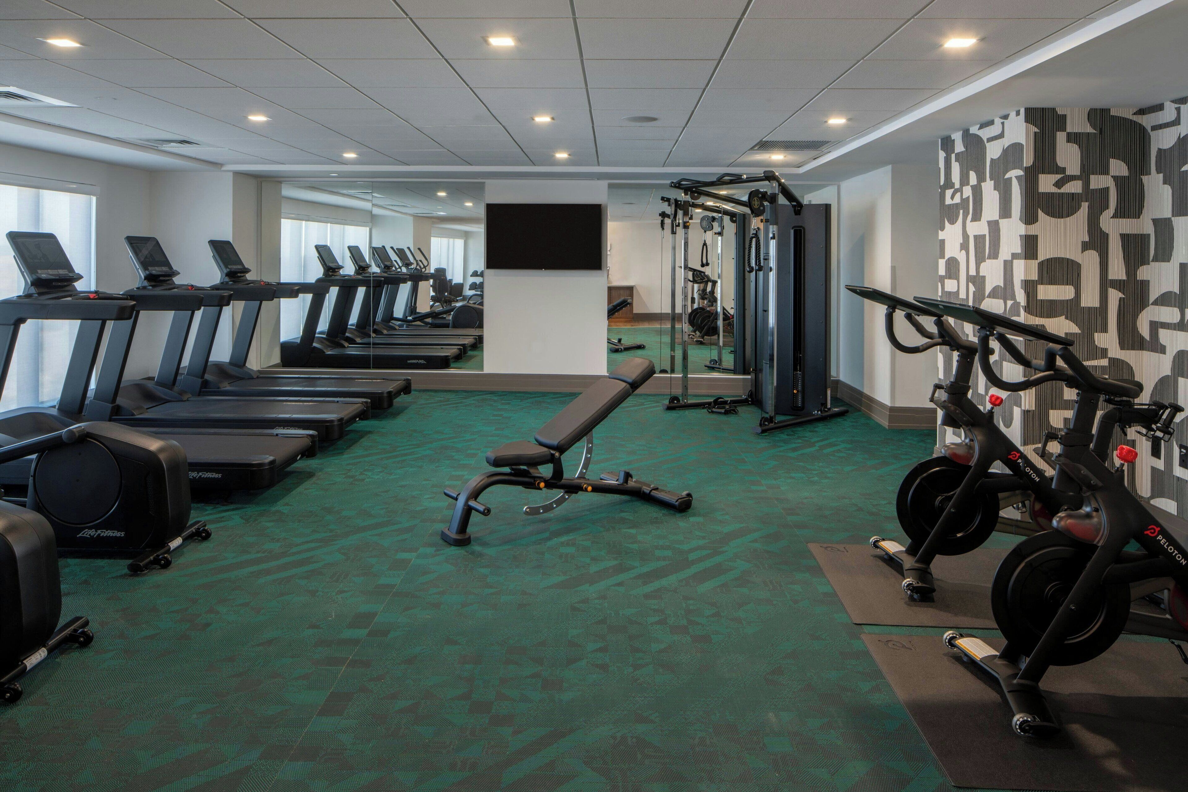 A gym with treadmills, a bench, and weight machines.