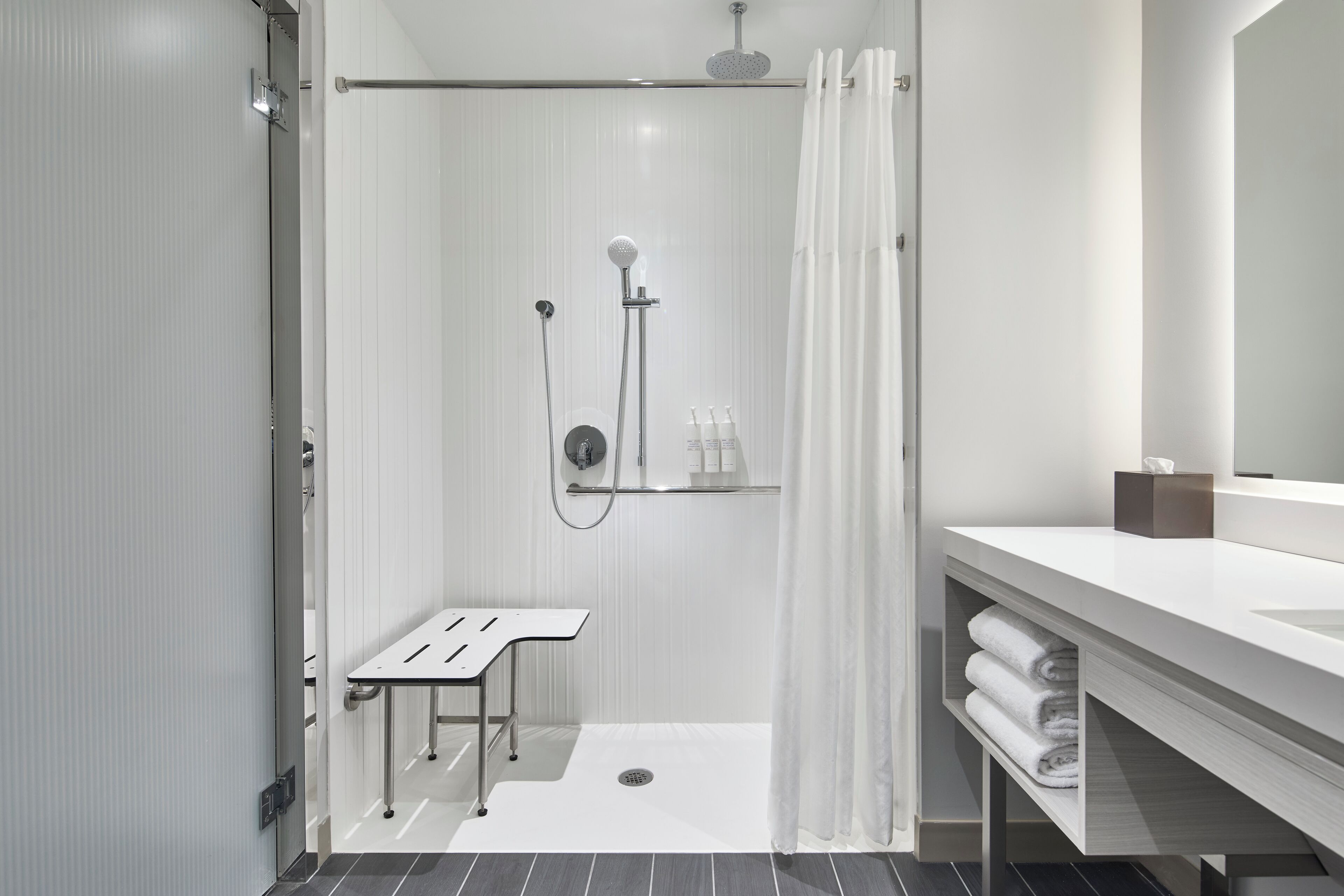 Ein modernes Badezimmer mit Dusche, Waschbecken und Spiegel.