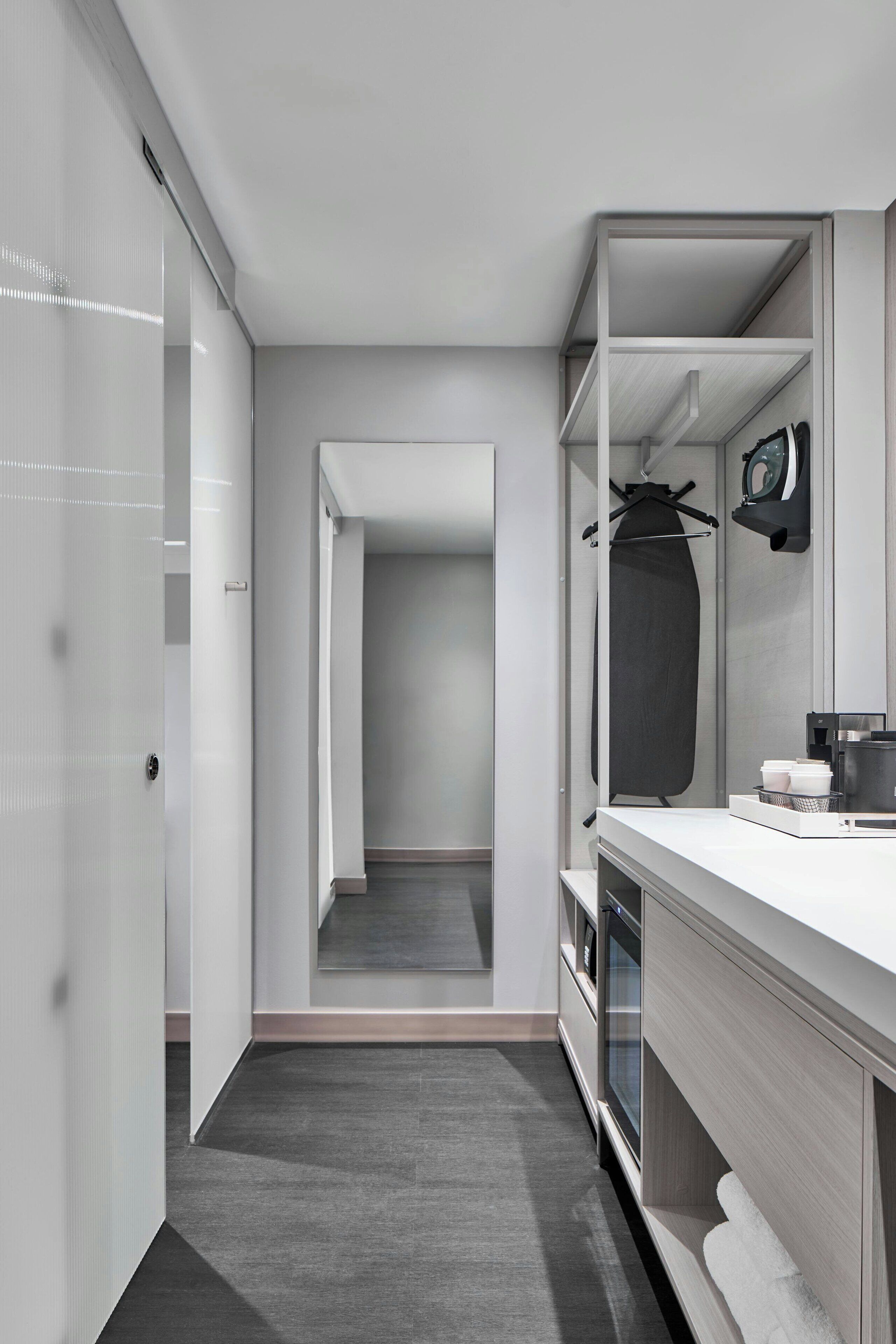 Une salle de bain moderne avec une douche à l’italienne, un meuble-lavabo avec un miroir et un porte-serviettes.