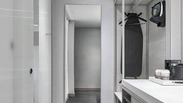 Une salle de bain moderne avec une douche à l’italienne, un meuble-lavabo avec un miroir et un porte-serviettes.