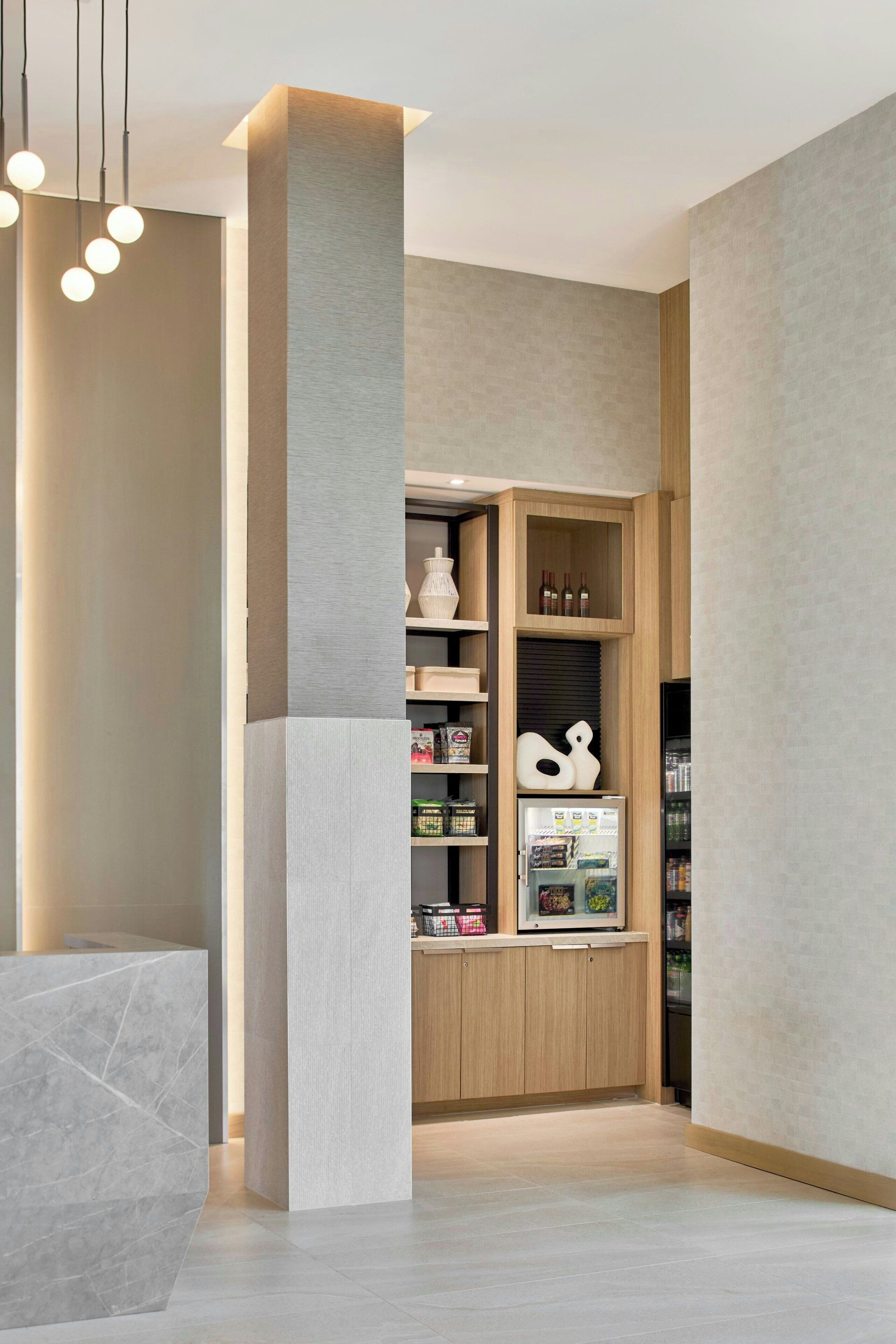 Eine moderne Küche mit Einbaukühlschrank, Holzschränken und einer Marmorarbeitsplatte.
