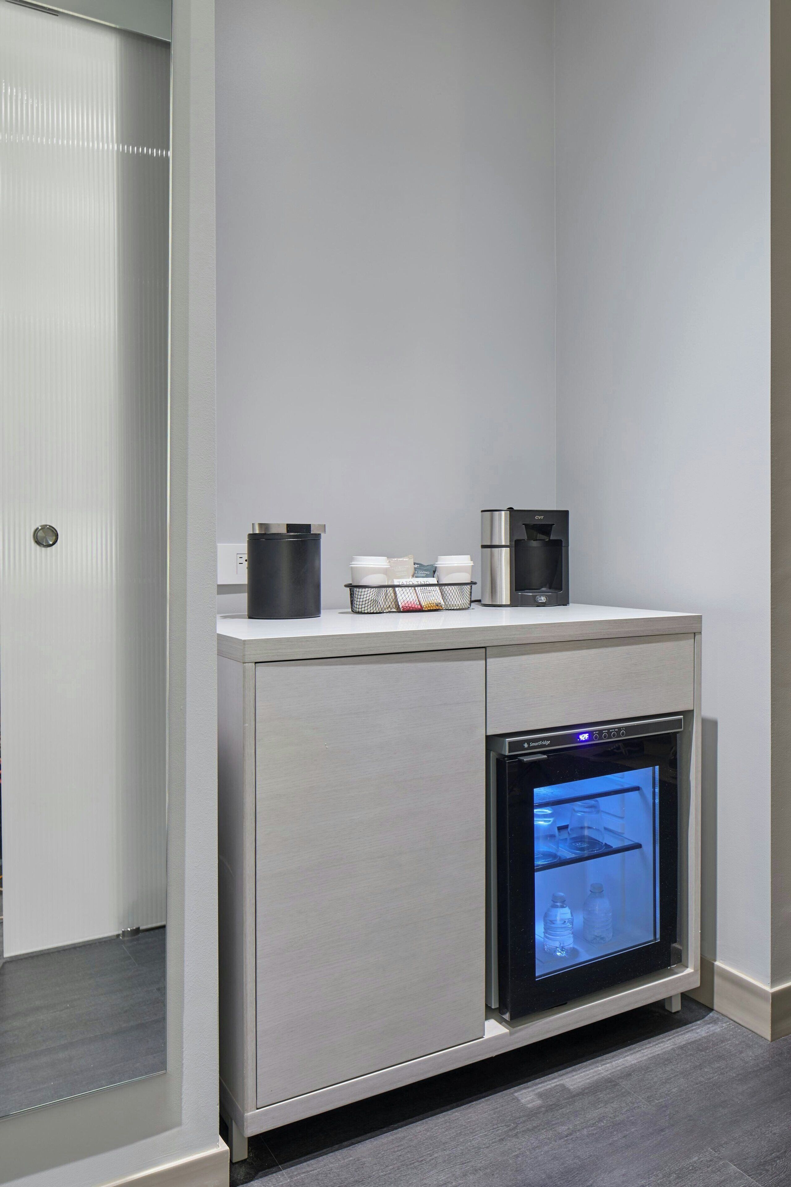 Eine moderne Küche mit eingebautem Ofen und Kaffeemaschine auf der Arbeitsplatte.