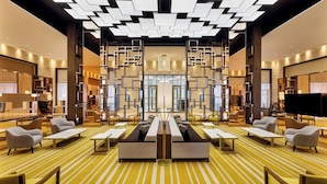 A modern lobby with a central seating area, multiple sofas, and a patterned carpet. - Sheraton Nouakchott Hotel (Nouakchott)