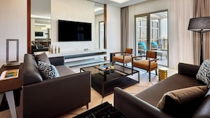 A modern living room with a sofa, armchairs, a coffee table, and a flat-screen TV mounted on the wall. - Sheraton Nouakchott Hotel (Nouakchott)