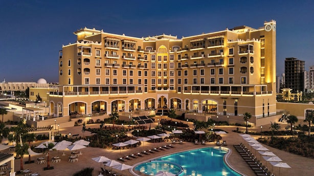 A large hotel with multiple balconies, a swimming pool, and outdoor seating areas. - Sheraton Nouakchott Hotel (Nouakchott)