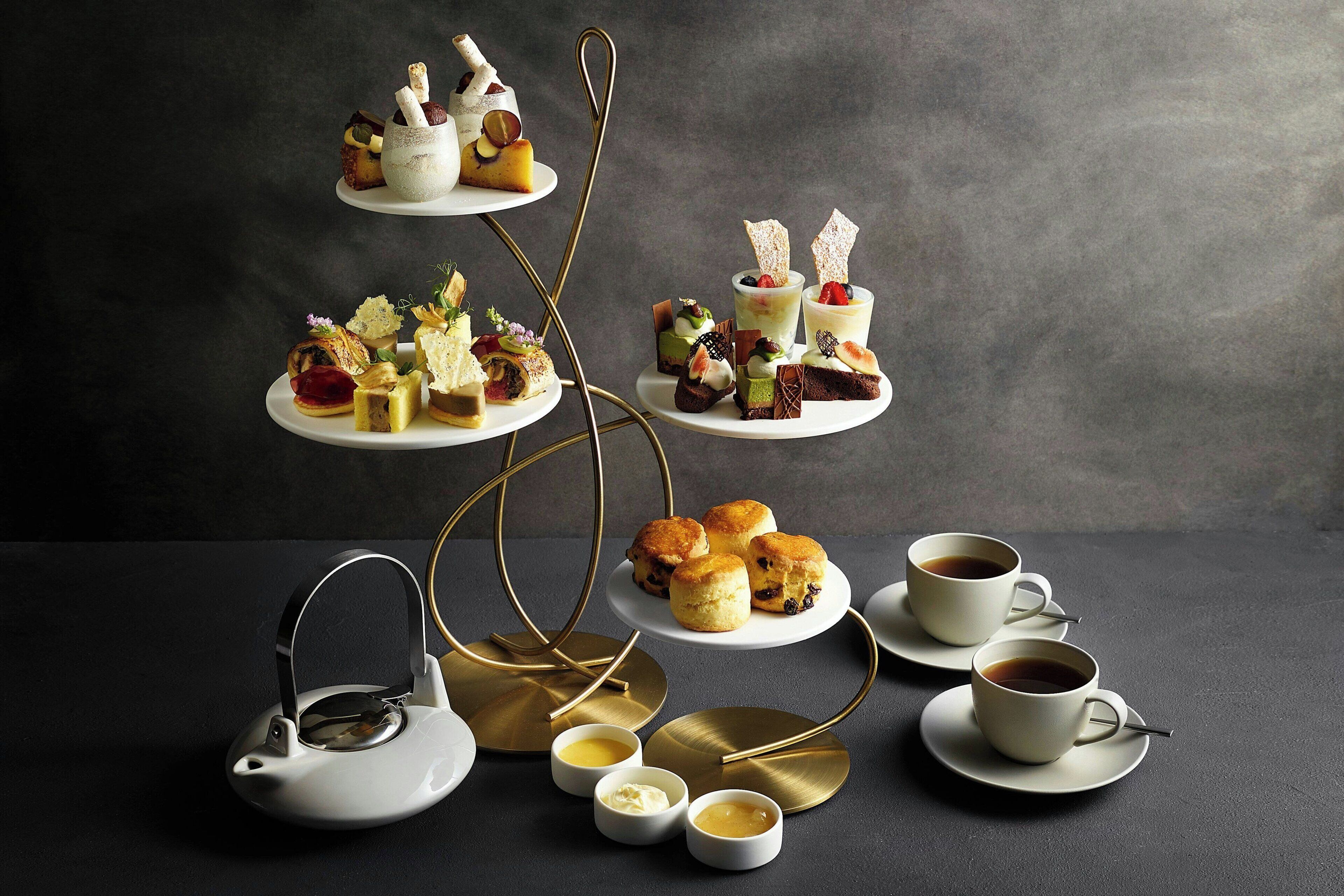 A tiered dessert display with various pastries and a tea set.