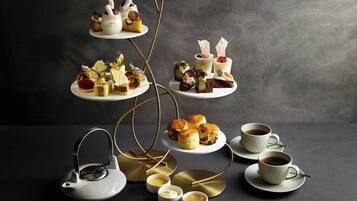 Une présentation de desserts à étages, comprenant diverses pâtisseries et un service à thé.