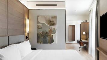 Een moderne hotelkamer met een groot bed, een bureau en een televisie.