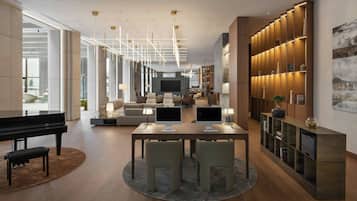 A modern living room with a piano, a TV, and a dining area with two monitors.