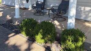A house with a porch, two chairs, a door with a glass panel, and a window with shutters. - Charming 3-bedroom house . Across the street from a beautiful walking track (McAlester)
