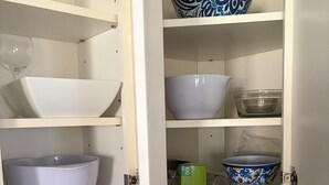 A kitchen cabinet with various bowls and a red appliance. - Charming 3-bedroom house . Across the street from a beautiful walking track (McAlester)