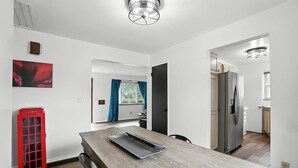 Eine moderne Küche mit einem Holztisch, einem roten Telefon und einem Kühlschrank.