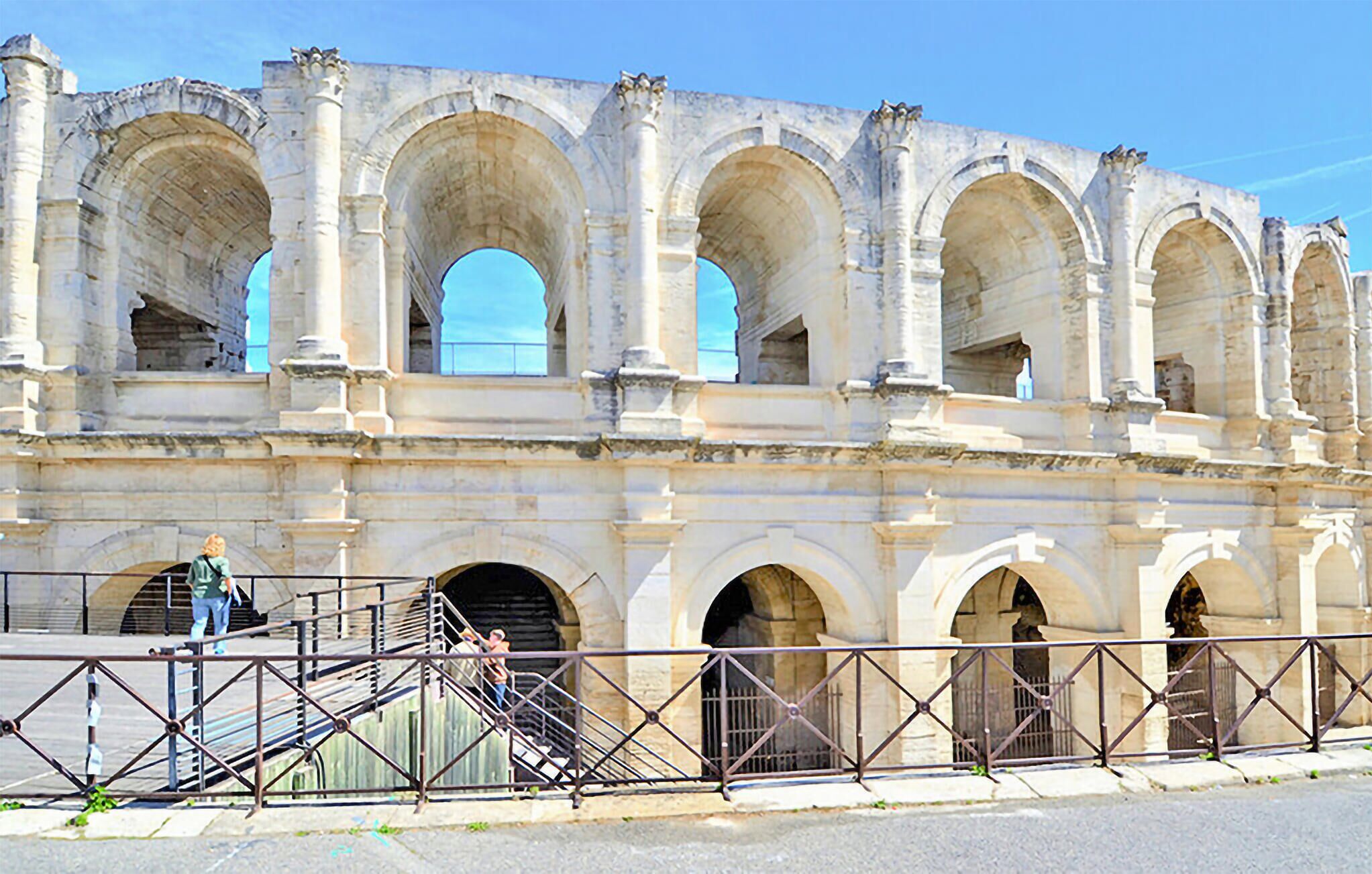 A historic stone structure with multiple arches and a staircase leading up to it.