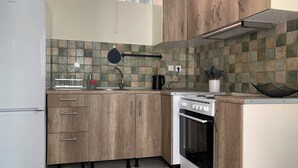Une cuisine avec des meubles de rangement en bois, une cuisinière et un réfrigérateur.