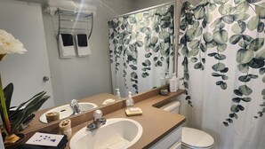 Ein Badezimmer mit Waschbecken, Spiegel und Toilette.
