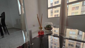 A modern room with a glass table, a small plant, and a candle.