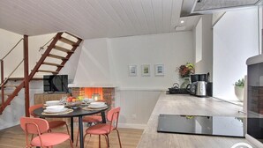 Una cocina moderna con comedor, una escalera y una chimenea.