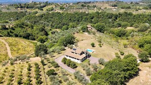 Un vaste domaine dont le bâtiment principal est entouré d’une végétation luxuriante et qui comprend une piscine.